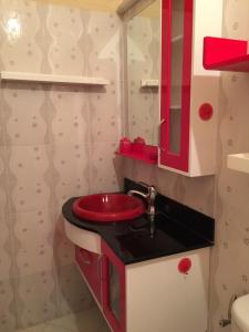 een badkamer met een rode wastafel en een rode spiegel bij Riad AL MAASSRA 