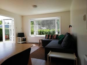 a living room with a couch and a table at Huisje VOS in Schoonloo