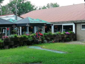 a restaurant with a lawn in front of a building at Huisje VOS in Schoonloo