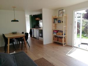 a living room with a table and a kitchen at Huisje VOS in Schoonloo
