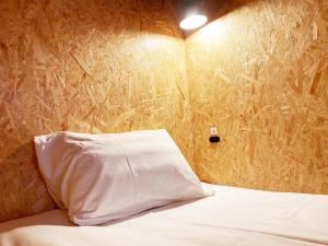 a bed with a white pillow in a room at ADLIV/Factry Stay/工場に泊まれる in Wakimachi