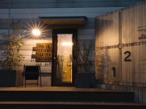 uma porta da frente de uma casa com uma luz sobre ela em ADLIV/Factry Stay/工場に泊まれる em Wakimachi