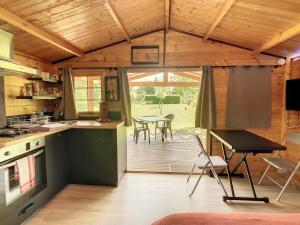 a kitchen and dining area of a wooden cabin at Le Châlet des Hortillonnages in Amiens