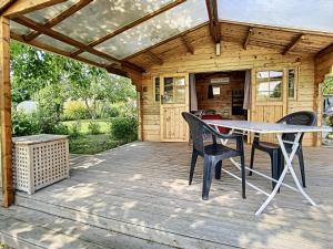 d'une terrasse avec une table et des chaises. dans l'établissement Le Châlet des Hortillonnages, à Amiens