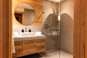 W łazience znajduje się umywalka oraz prysznic z lustrem. w obiekcie Hotel Winterbauer w mieście Flachau