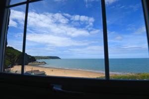 a view of a beach from a window at Ship Inn in Aberporth