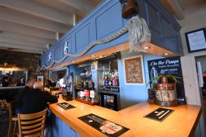 Ein Mann sitzt in einer Bar in einem Restaurant. in der Unterkunft Ship Inn in Aberporth