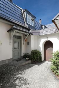 a white house with a door and a garage at BohnApartments Steigerwald - Natur in der Stadt - Vollausstattung - WLAN - Parkplätze in Erfurt