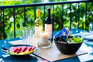 uma mesa com uma garrafa de vinho e uma taça de fruta em Haus Eleonas em Kalivia Poligirou