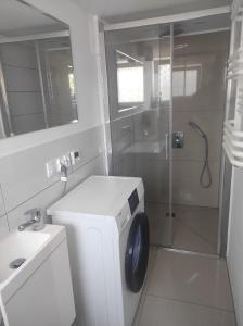 ein Badezimmer mit Waschmaschine und Dusche in der Unterkunft Apartament przy plaży in Danzig