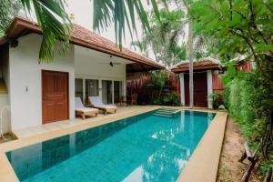 a swimming pool in front of a villa at Villa Raya Resort Private Pool Villas in Pattaya North