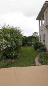 a yard next to a house with flowers and a building at Acaba d'Entrar in Le Caylar