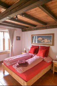 a bedroom with a large bed with red pillows at Coeur de montagne in Gignod