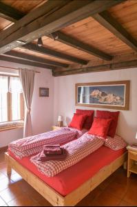 une chambre avec un grand lit avec des oreillers rouges dans l'établissement Coeur de montagne, à Gignod