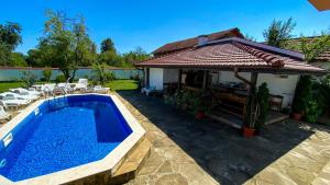 a pool in a yard with chairs and a house at DE-YAN Guest House in Oreshak