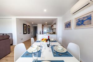 a dining room and living room with a table and chairs at Apartment Faroles 1 By SunVillas Mallorca in Port de Pollensa