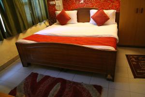 un letto con cuscini arancioni e bianchi in una stanza di DIAMOND PALACE a Chandīgarh