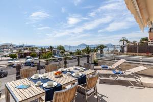 a balcony with tables and chairs and a view of the ocean at Apartment Faroles 1 By SunVillas Mallorca in Port de Pollensa