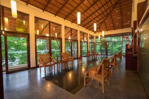Habitación grande con sillas, mesas y ventanas. en Tea Valley Resort, Munnar, en Munnar