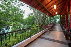 a balcony with chairs and tables and trees at Tea Valley Resort, Munnar in Munnar