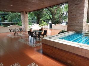 a patio with a swimming pool and tables and chairs at Aster Residence in Chiang Mai