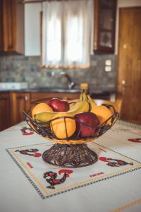 波爾塔里亞的住宿－Violetta's House Παραδοσιακή Βίλα στην Πορταριά，坐在桌子上一碗水果
