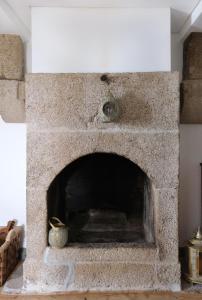 a stone fireplace in a living room at Casa da Praça - Guest House in Pinhel