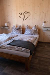 1 dormitorio con 1 cama con 2 corazones en la pared en Tiny-House mit großer Terrasse zum Genießen!, 