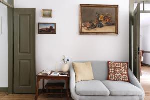 uma sala de estar com um sofá e uma pintura na parede em Casa da Praça - Guest House em Pinhel
