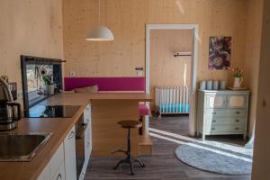 uma cozinha com um balcão e um banco num quarto em Tiny-House mit großer Terrasse zum Genießen! 