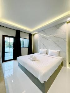 um quarto com uma cama grande e uma parede em mármore em Lamer Ville em Chanthaburi