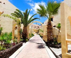 einen Gehweg mit Palmen vor einem Gebäude in der Unterkunft Mareverde holiday's, 1 room & big terrace in Adeje