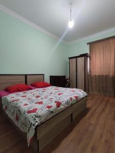 Schlafzimmer mit einem Bett mit einer roten und weißen Decke in der Unterkunft Old Jermuk 