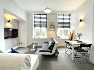 1 dormitorio con cama, escritorio y sofá en Modern Family Apartment FREE Parking and Gym by Beach, en Bournemouth