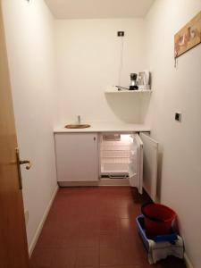 a small white kitchen with a refrigerator and a sink at Appartamenti Val di Fassa Passo Costalunga 223, 119, 114 in Vigo di Fassa