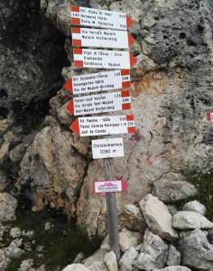 a directional sign on the side of a mountain at Appartamenti Val di Fassa Passo Costalunga 223, 119, 114 in Vigo di Fassa