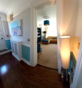 a living room with a hallway with a room with a couch at Beautifully appointed, period seaside apartment in Folkestone