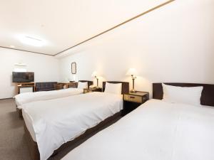 a hotel room with two beds and a tv at Tabist Hotel New Washington Shibuya in Tokyo