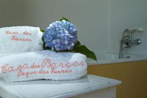 a bunch of towels sitting on a counter with a flower at Casa Dos Barcos Furnas in Furnas