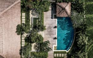 an overhead view of a swimming pool and trees at The Retreat at Kharista by Ekosistem in Canggu