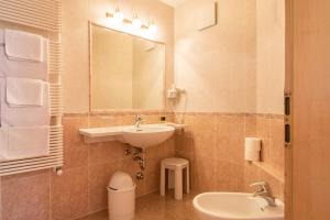 a bathroom with a sink and a mirror and a toilet at Hotel Residence Gardena Alps 300 in Santa Cristina in Val Gardena +21 photos