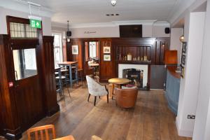 a room with a fireplace and a table and chairs at The Bath Arms Hotel in Cheddar +37 photos