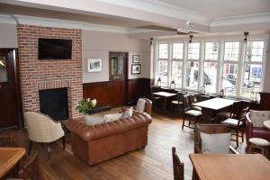 a living room with a couch and a fireplace at The Bath Arms Hotel in Cheddar