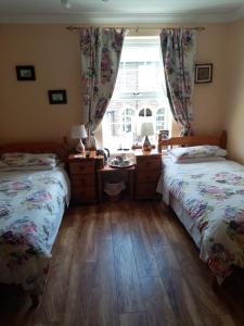 a bedroom with two twin beds and a window at The Guest House in Abergavenny