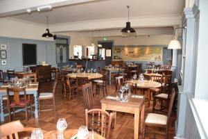 a restaurant with wooden tables and chairs in a room at The Bath Arms Hotel in Cheddar