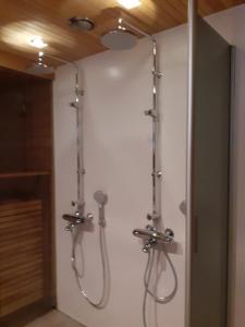 a bathroom with two shower systems on a wall at Villa Vuossel in Ruka
