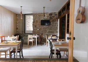 a restaurant with tables and chairs and a guitar at Casa da Praça - Guest House in Pinhel