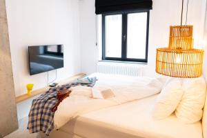 Schlafzimmer mit einem Bett, einem TV und einem Kronleuchter in der Unterkunft Espace 43 - Les 7 chambres in Namur