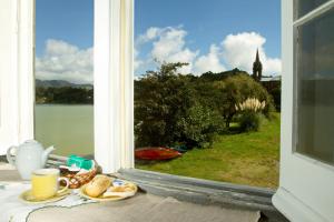 Casa Dos Barcos Furnas في فورناس: صحن من الطعام على طاولة تطل على نافذة