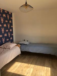 um quarto com 2 camas e um lustre em Villa Bailey em Quiberon